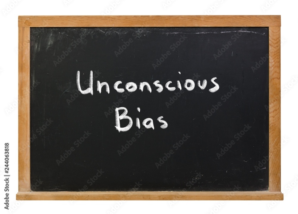 Unconscious Bias written in white chalk on a black chalkboard isolated on white Unconscious Bias written in white chalk on a black chalkboard isolated on white