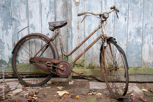 Verrostetes altes Fahrrad lehnt an einer Holzwand