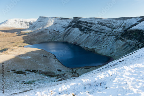 lake with snowy mountains and sun (llyn y fan fach, brecon beacons national park)
