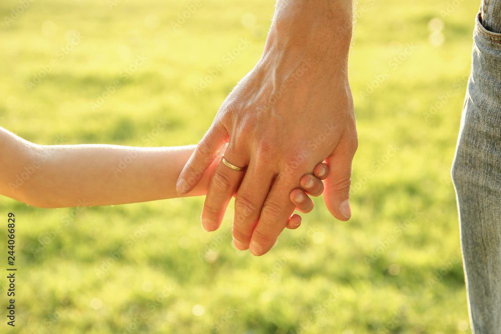  parent holds the hand of a small child