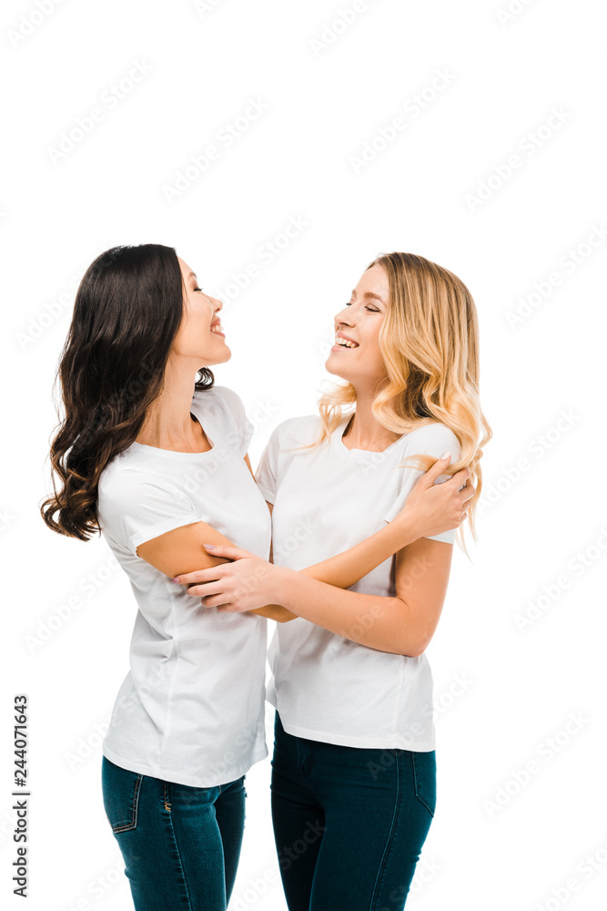 happy young women in white t-shirts hugging and smiling isolated on white happy young women in white t-shirts hugging and smiling isolated on white