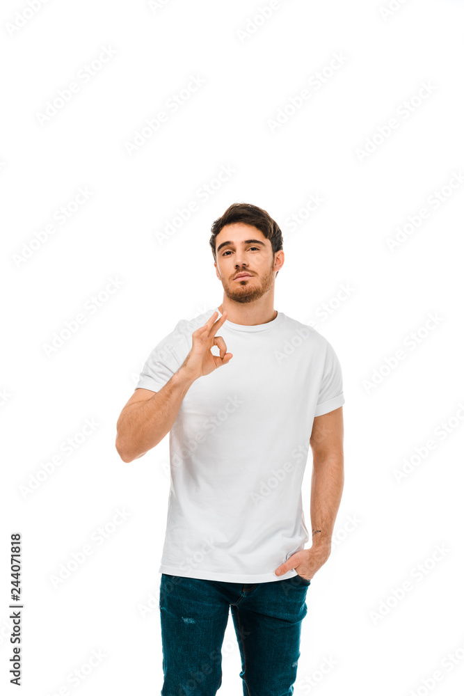 confident young man showing ok sign and looking at camera isolated on white confident young man showing ok sign and looking at camera isolated on white