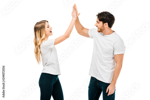 happy young couple giving high five and smiling each other isolated on white