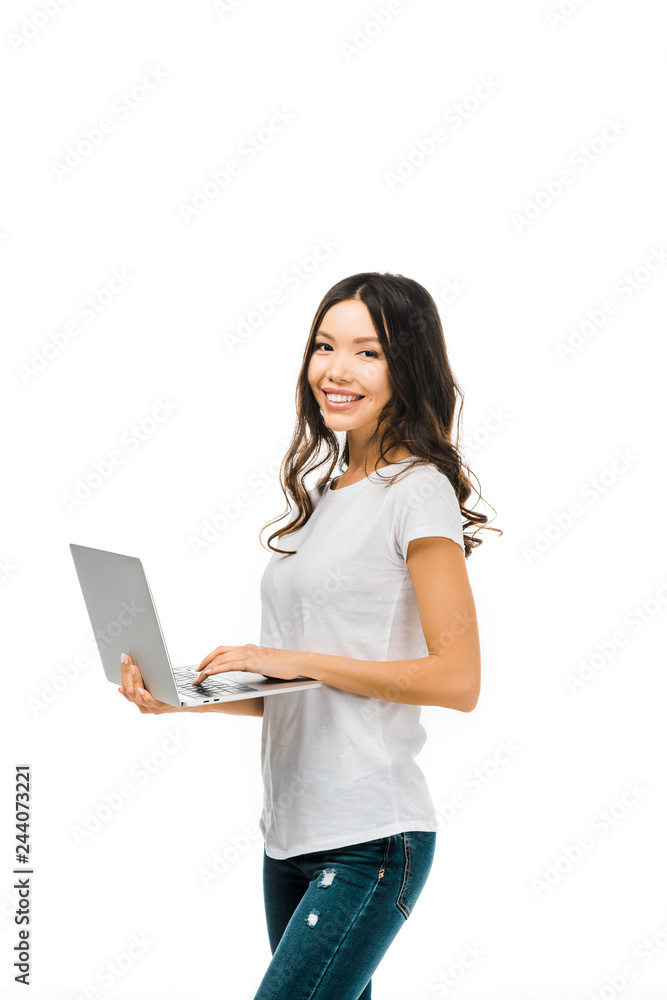 happy young woman using laptop and smiling at camera isolated on white happy young woman using laptop and smiling at camera isolated on white