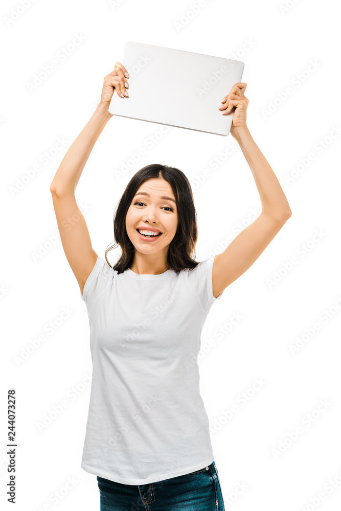 happy young woman holding laptop above head and smiling at camera isolated on white happy young woman holding laptop above head and smiling at camera isolated on white