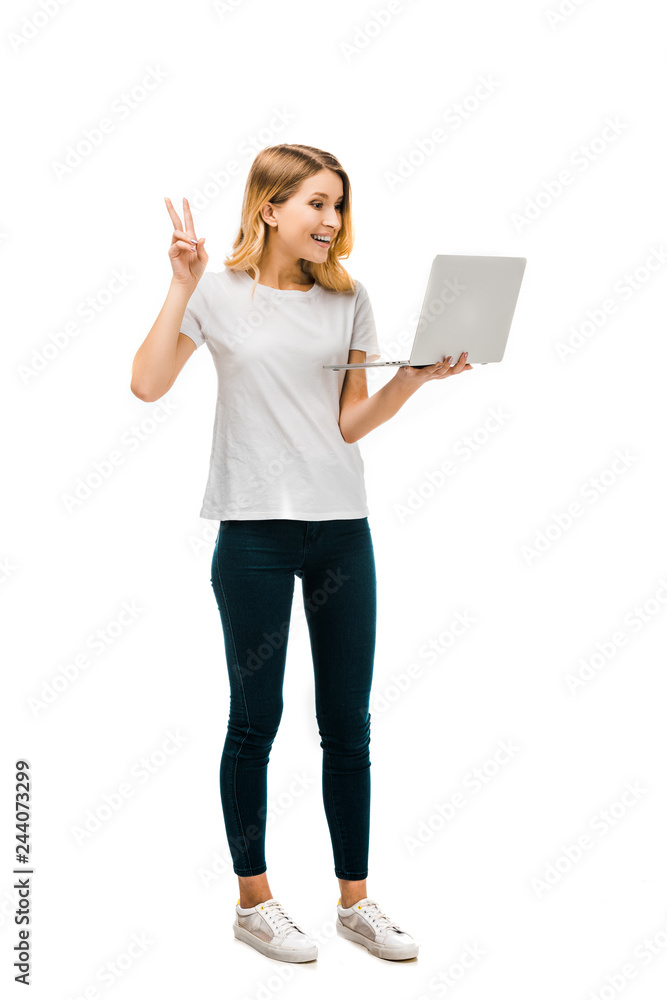 happy young woman holding laptop and showing victory sign isolated on white happy young woman holding laptop and showing victory sign isolated on white