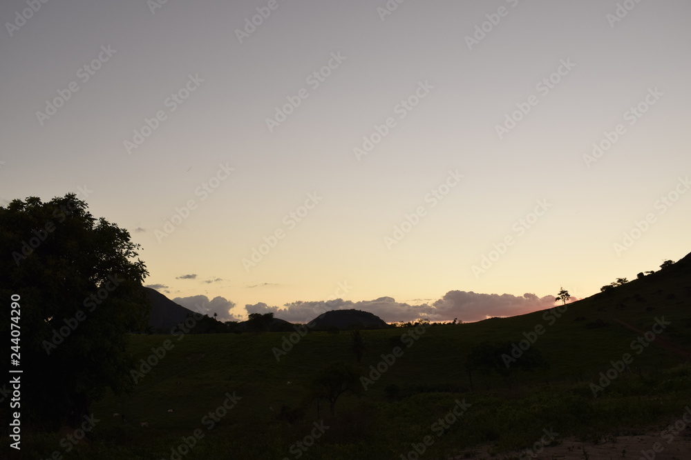 Pôr-do-sol em paisagem rural, silhueta de horizonte