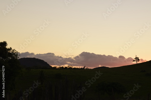 Pôr-do-sol em paisagem rural, silhueta de horizonte