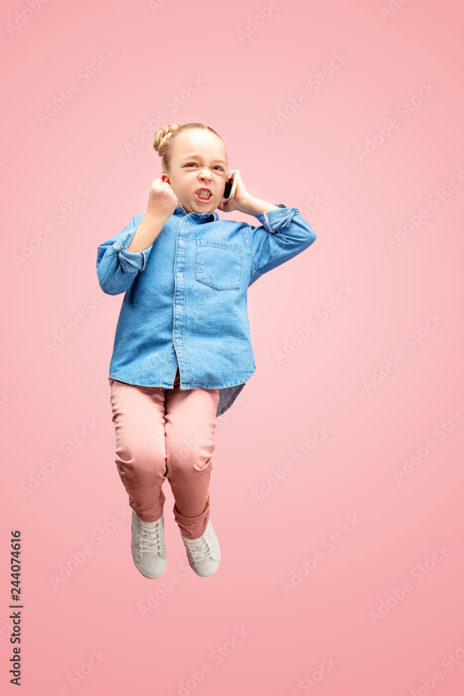 Young happy surprised caucasian teen girl jumping with mobile phone in the air, isolated on pink studio background. Beautiful female full length portrait. Human emotions, facial expression concept. Young happy surprised caucasian teen girl jumping with mobile phone in the air, isolated on pink studio background. Beautiful female full length portrait. Human emotions, facial expression concept.