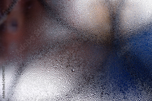 Water drops on glass window close up with blurred background. Drops in macro. Condensate on window closeup. Wet air.