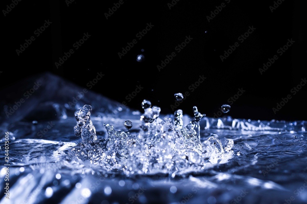 Water drops splashing on acoustic membrane. A lot of drops in air. High frequency of sound waves. Water cloud small drops. Frozen time shot.