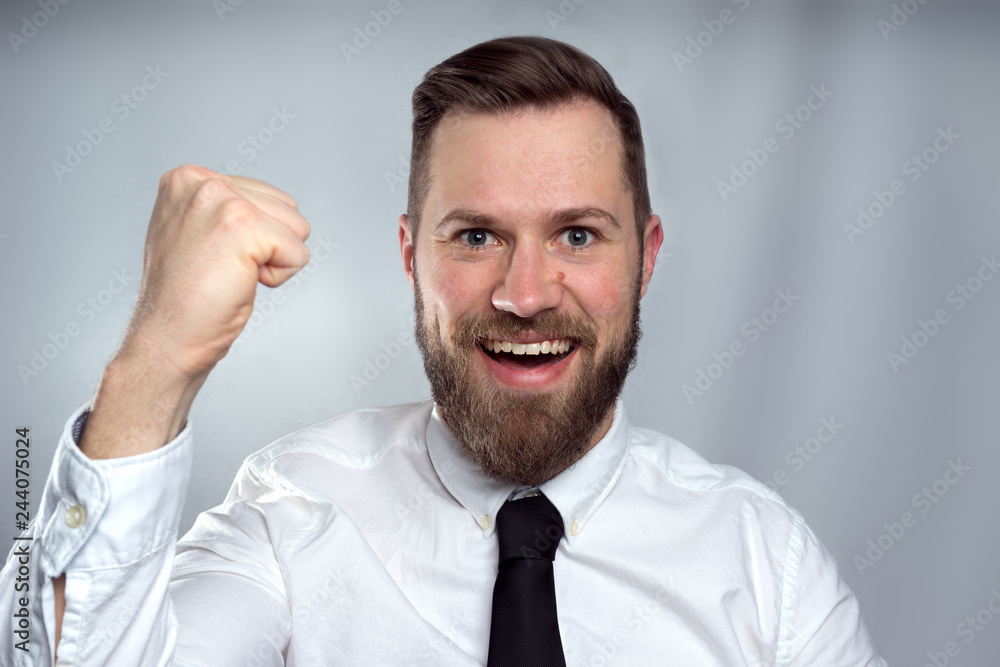 Happy business man celebrating and smiling isolated on grey studio background. Happy business man celebrating and smiling isolated on grey studio background.