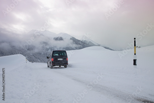 Van driving along snowcapped mountain road