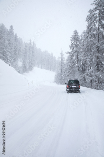 Van driving along snowcapped mountain road