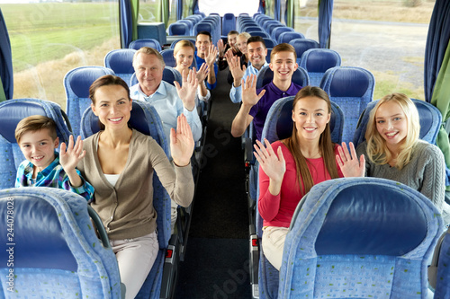 transport, tourism and travel concept - group of happy passengers travelling by bus and waving hands