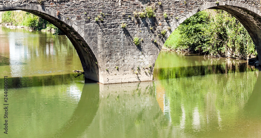 Stone bridge in a river on a sunny day.