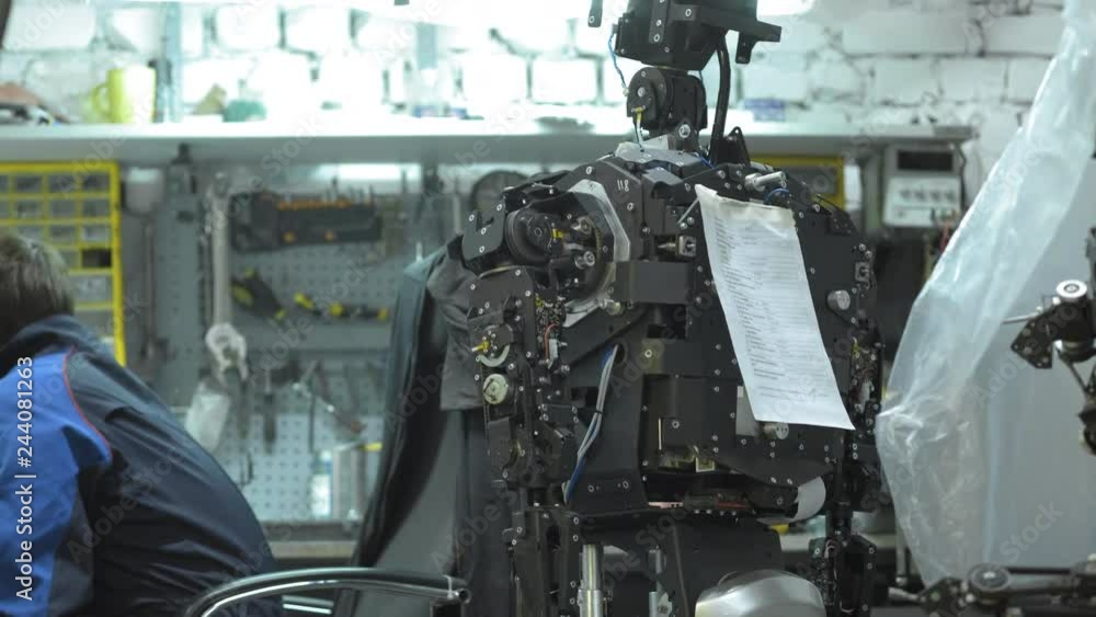 Cybernetic system today. Researcher creates a modern robot or android. Checks the moving mechanism in the legs of the robot. Manufacture and manufacture of robots. Cybernetic system today. Researcher creates a modern robot or android. Checks the moving mechanism in the legs of the robot. Manufacture and manufacture of robots.