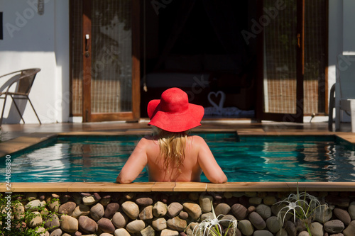 Young blonde beautiful woman in sunglasses in swimming pool bathing