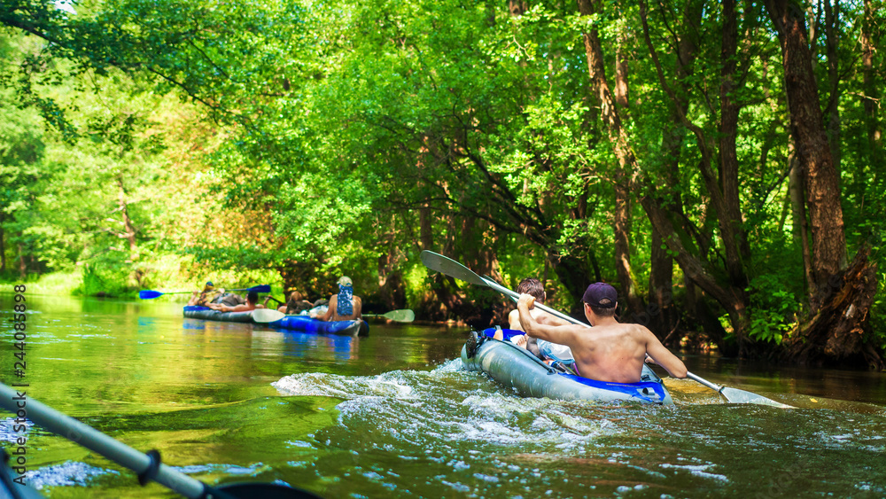 Friends in canoe swim on forest river