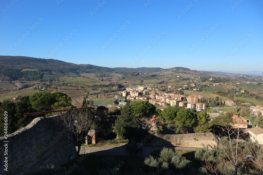 Walls of Rocca di Montestaffoli fortress with tuscany landscape on the background, San Gimignano, Italy