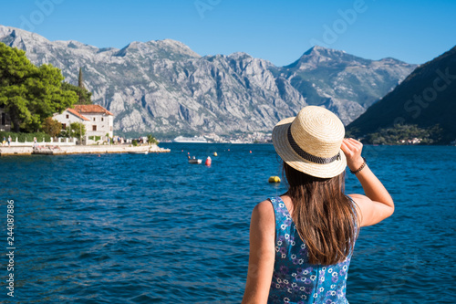 Back view of a young beautiful woman in a hat looking to the old town Budva, Montenegro © Nickolay Khoroshkov