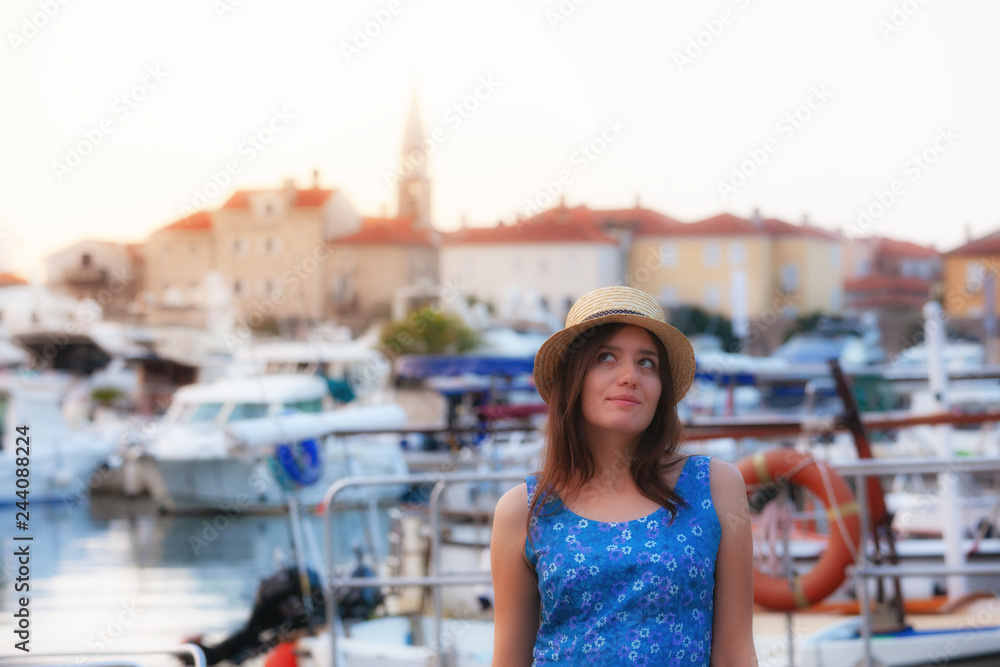 Europe summer travel mediterranean destination. Tourist woman on vacation, walking on the streets of old and beautiful Mediterranean city in hat and summer dress