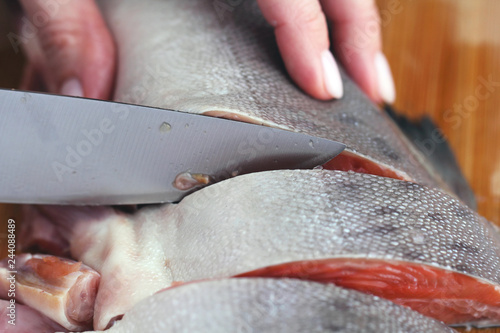 Hand carving a trout steak with a sharp knife