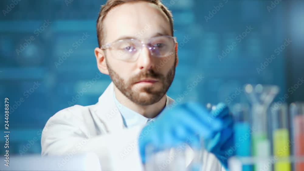 Medium close-up male scientist wearing glasses and gloves working in modern laboratory Medium close-up male scientist wearing glasses and gloves working in modern laboratory