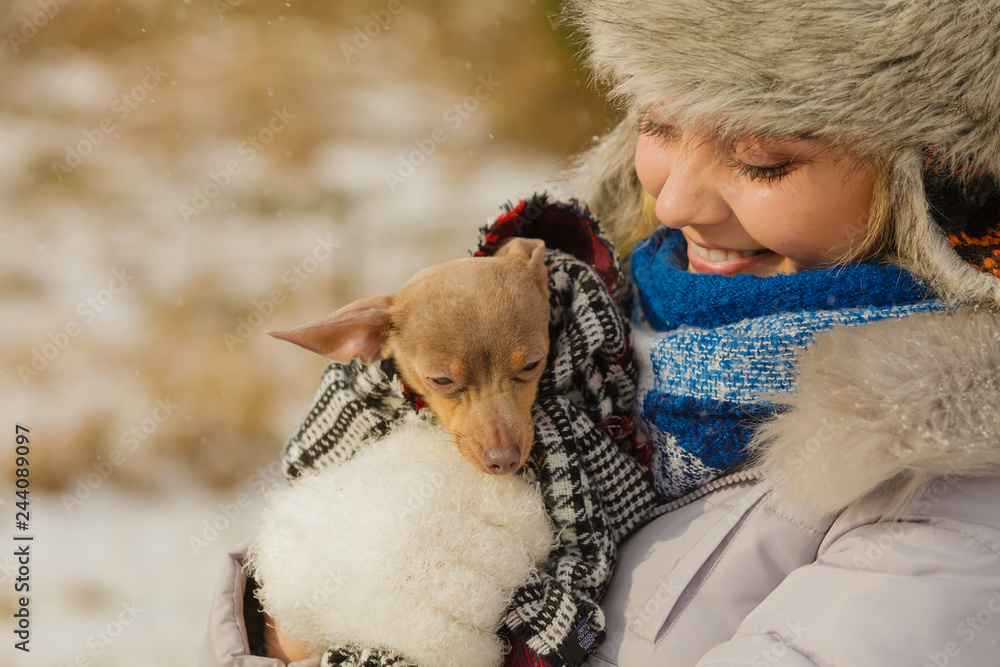 Woman hug warming her little dog in winter Woman hug warming her little dog in winter