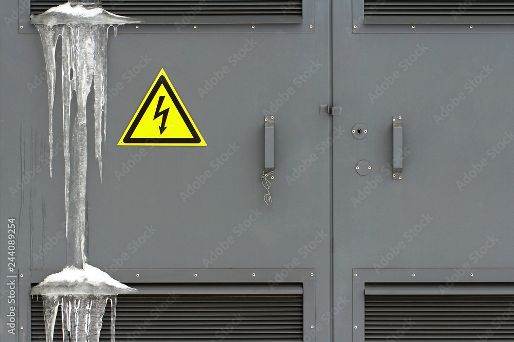 Locked electric panel with hazard sign on the grey door of transformer