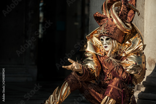 Gesturing person in Venetian carnival costume of Harlequin