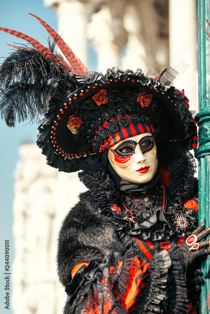 Woman in Venetian carnival costume wearing plumage hat