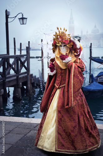 Woman in Venetian carnival outfit in lagoon