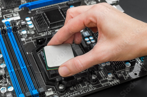 Hand puts computer processor on motherboard.