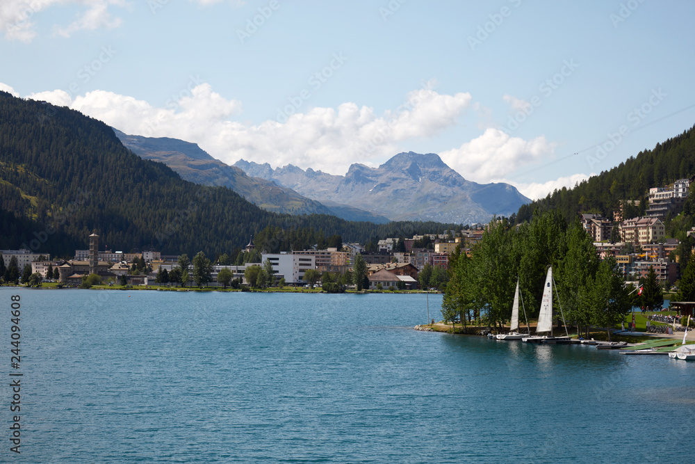 Sankt Moritz town and lake with sail boats in a sunny summer day in Switzerland