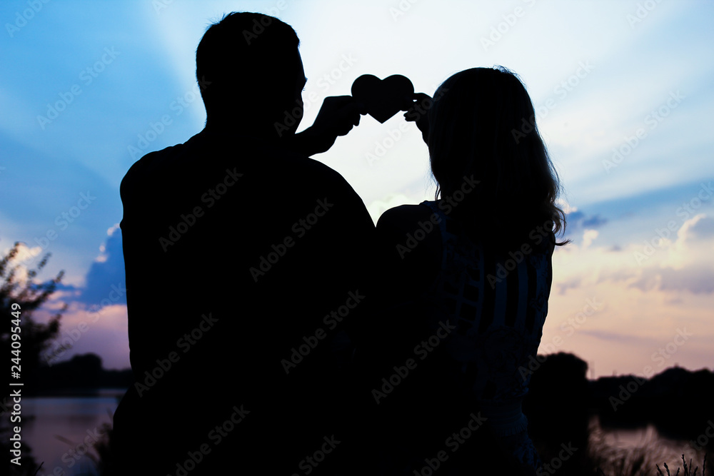 happy couple silhouette on the sunset background nature
