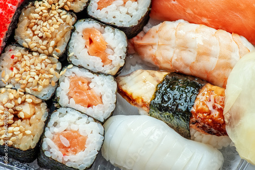 Schilderij op canvas Multicolored rolls and sushi rice, caviar and salmon, eel, trout on the table in