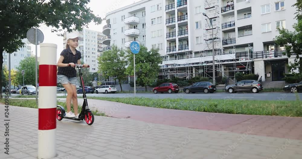 Cheerful girl riding a scooter in the summer city. Cheerful girl riding a scooter in the summer city.