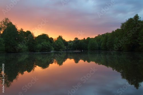 Sunrise reflection on the Lake. Burger lake. Tree near the lake. Symmetrical refflection.