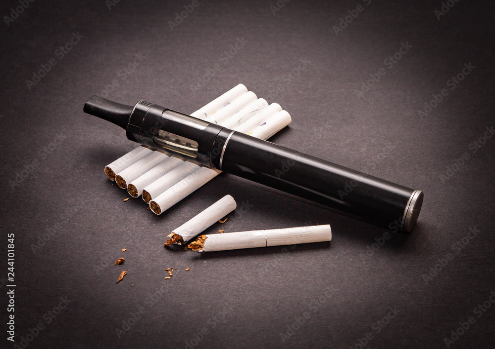 the concept of anti - Smoking vaporizer is on the cigarette isolate on dark background the concept of anti - Smoking vaporizer is on the cigarette isolate on dark background