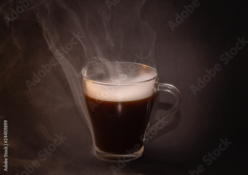 the concept of really hot coffee with cream on a dark isolated background