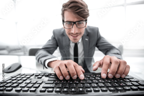 young man using keyboard , closely and carefully looking at the 