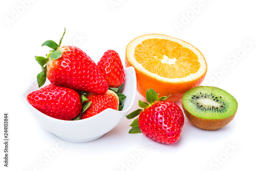 ripe strawberries in a plate orange and kiwi on a white background