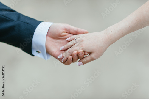 the groom holds the bride's hand. soft focus