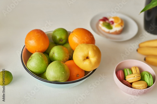 Fruits  apples  watermelon  pineapple  bananas  lemons  oranges o table  warm loft-style kitchen. Plate of ripe fruits on table. Home modern kitchen table top decorated with summer exotic fruits 