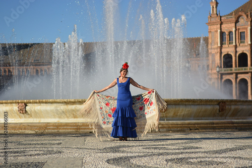 the girl with the blue flamenco dress in front of the fountain