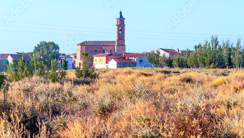 Rural village in the north of Spain surrounded by cultivated fields on a sunny day.