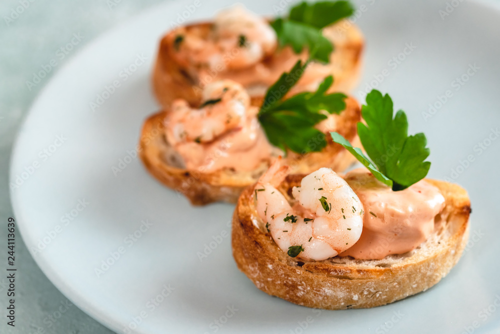 Bruschetta sandwiches with shrimps, creamy sauce and parsley. Bruschetta sandwiches with shrimps, creamy sauce and parsley.