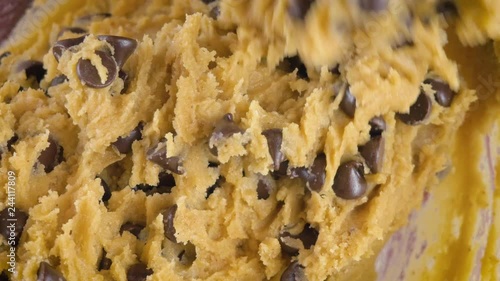 Closeup stirring chocolate chips into raw cookie dough in 4k. Top view can be used for step by step gif recipes for cooking shows, salmonella outbreaks and unhealthy diets from refined sugar. 