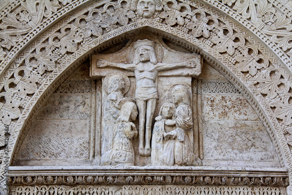 Cristo in croce e Santi; primo portale sul fianco nord della Cattedrale dell'Assunta a Conversano (Puglie)